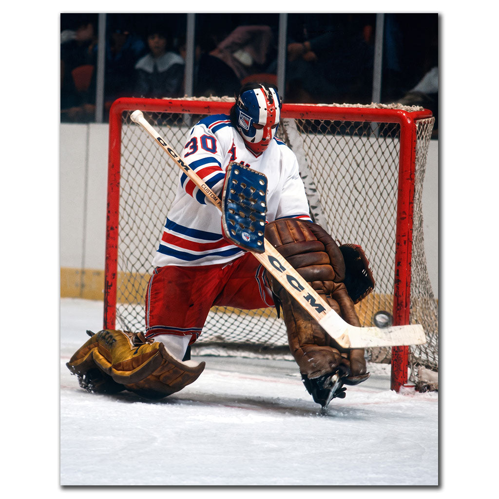 John Davidson New York Rangers 8x10 hockey photo wearing a white jersey and red, white and blue goalie mask while holding a ready stance beside the net with vintage brown pads for autograph pre-order