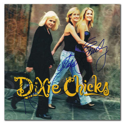 Three women smile with a signed 12x12 flat featuring Emily Strayer, Martie Maguire, and Natalie Maines of the Dixie Chicks.