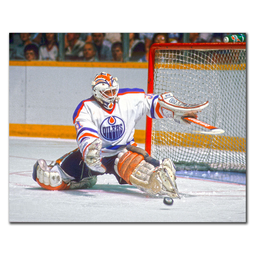 Grant Fuhr making a save in a white Edmonton Oilers uniform