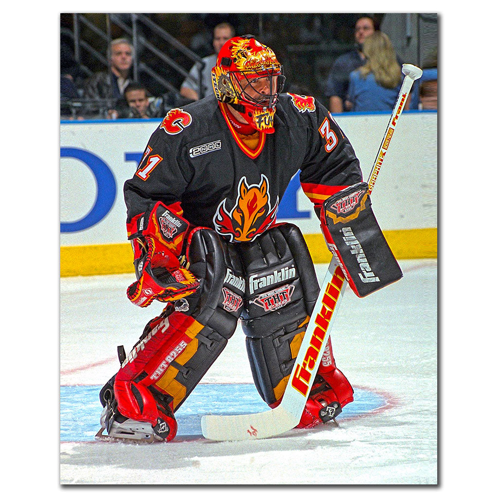 Grant Fuhr tending goal in a black Calgary Flames uniform