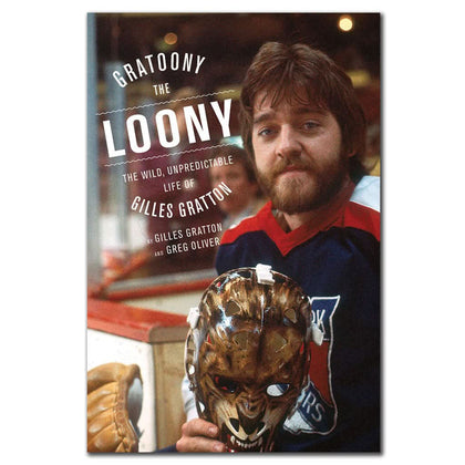 A bearded hockey player holds a mask beside a signed softcover edition of Gratoony the Loony, perfect for memorabilia displays.