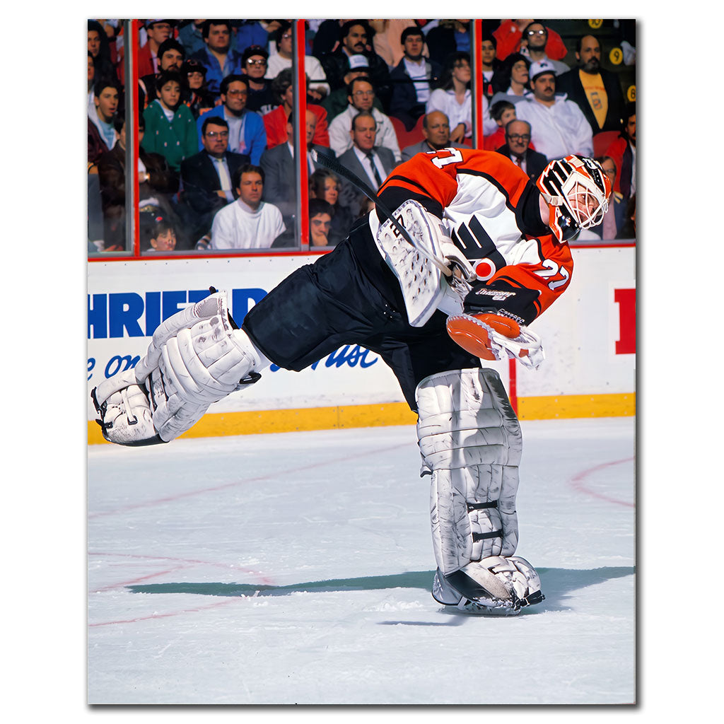 Ron Hextall Philadelphia Flyers 8x10 hockey photo in a white and orange goalie uniform leaning forward while playing the puck for autograph pre-order