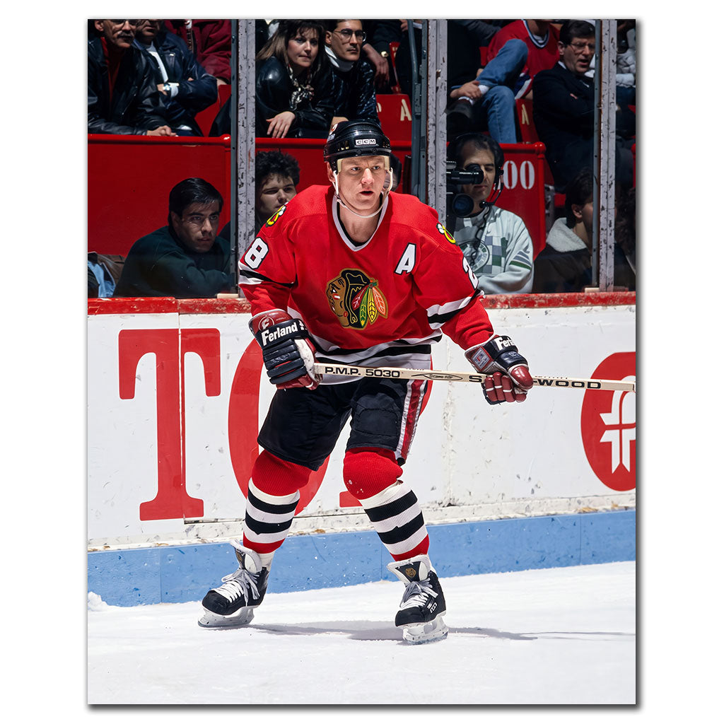 Steve Larmer beside the boards in a red Chicago Blackhawks uniform