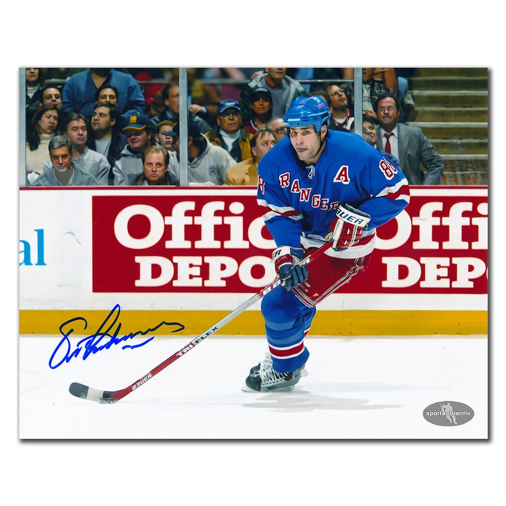 Eric Lindros autographed New York Rangers 8x10 photo in blue jersey skating with puck