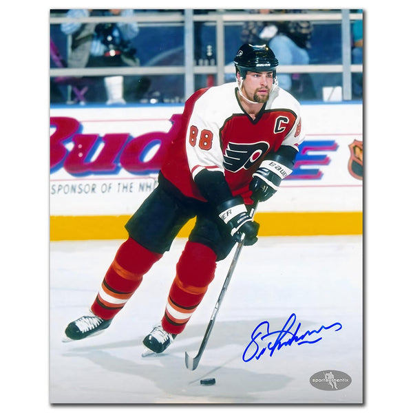 Eric Lindros autographed Philadelphia Flyers 8x10 photo in orange jersey skating with puck