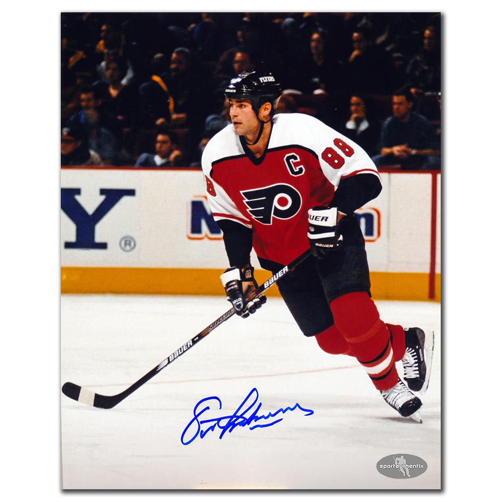 Eric Lindros autographed Philadelphia Flyers 8x10 photo in orange jersey stickhandling on the ice