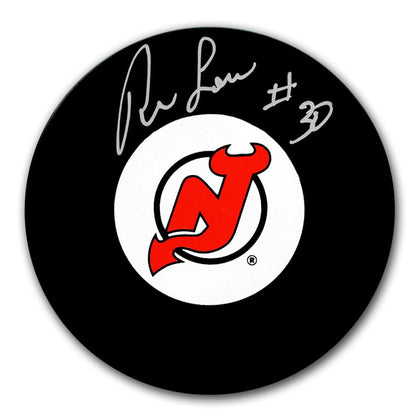 Ron Low autographed New Jersey Devils hockey puck, featuring his signature on the teams official game puck—premium NHL collectible.