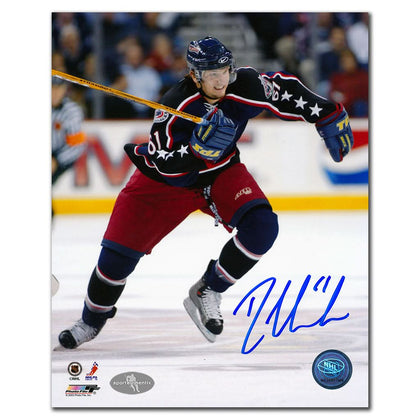 Hockey player in blue and red uniform skating, with a signed 8x10 photo inscribed BREAKOUT by Rick Nash of the Blue Jackets below.