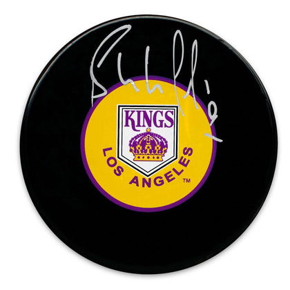 Bernie Nicholls autographed Los Angeles Kings puck featuring a vintage logo on a black surface, perfect for collectors.