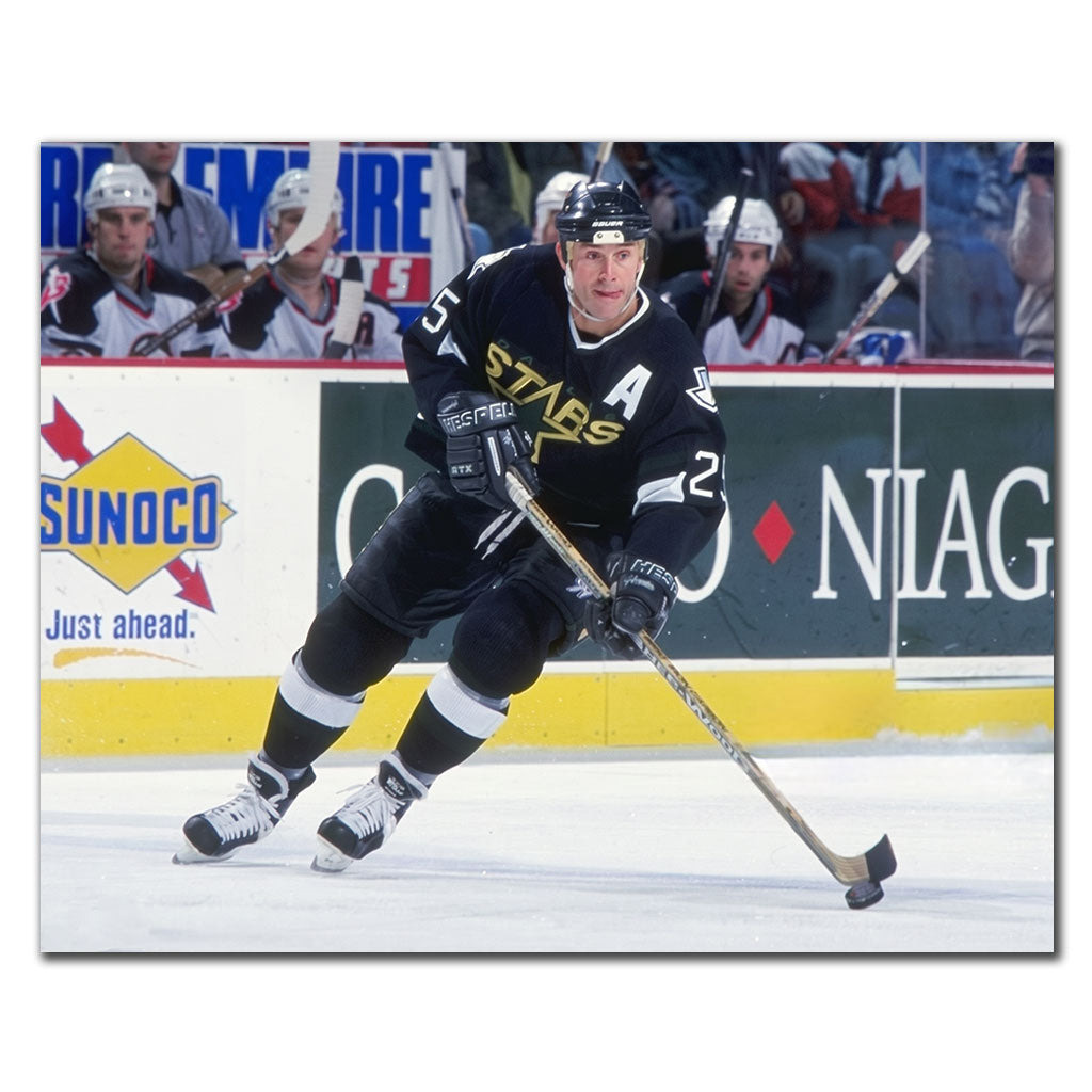 Joe Nieuwendyk in a Dallas Stars black jersey skating with the puck