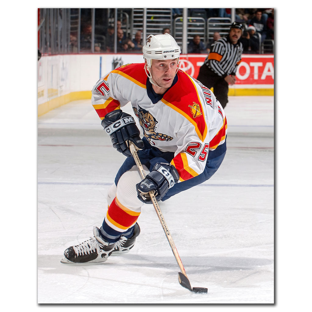 Joe Nieuwendyk in a Florida Panthers white jersey skating with the puck