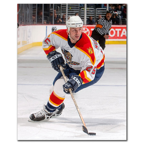 Joe Nieuwendyk in a Florida Panthers white jersey skating with the puck