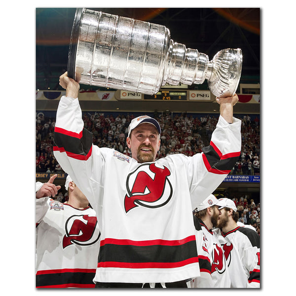 Joe Nieuwendyk in a New Jersey Devils white jersey raising the Stanley Cup overhead