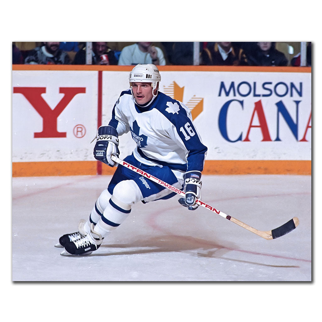 Ed Olczyk skating with his stick in a white Toronto Maple Leafs jersey