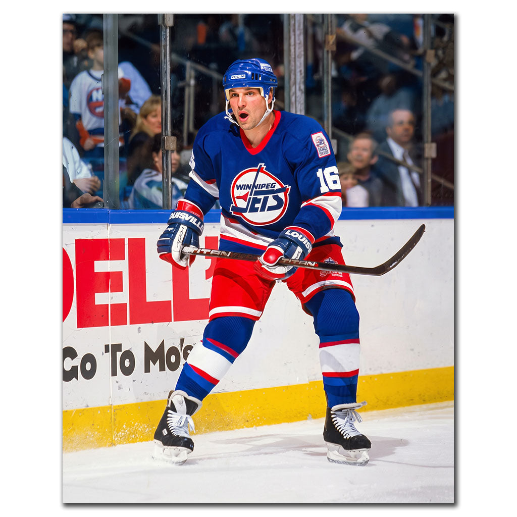 Ed Olczyk standing near the boards in a blue Winnipeg Jets jersey during an NHL game