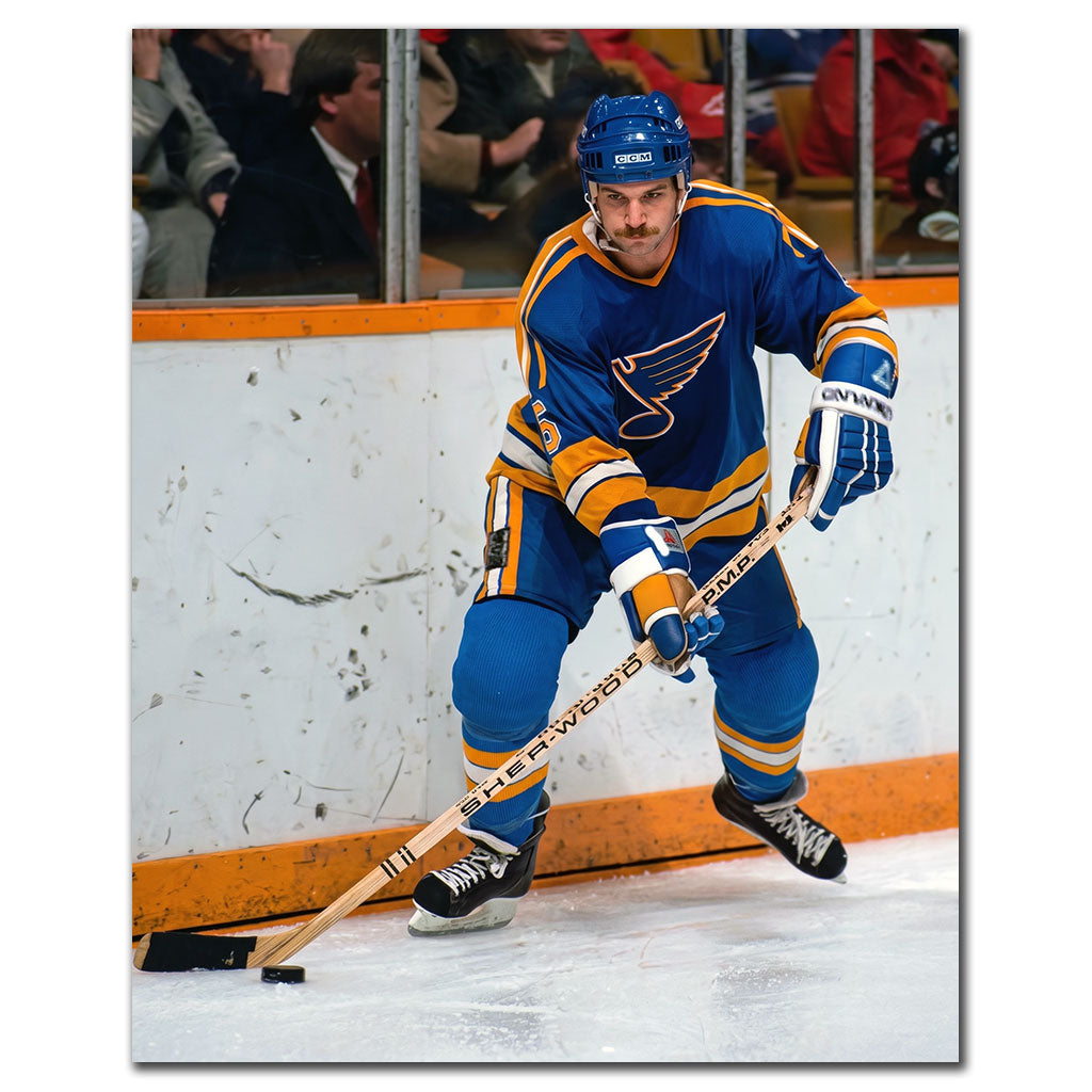 Rob Ramage carrying the puck in a blue St. Louis Blues uniform