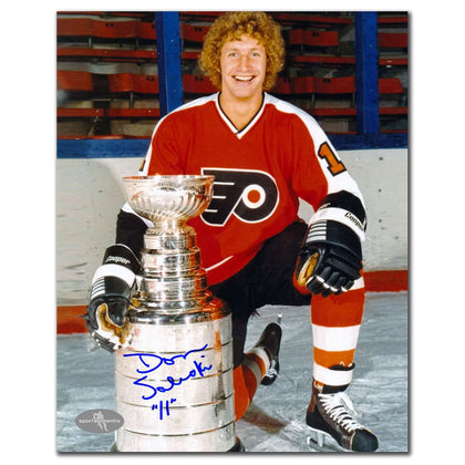 Autographed 8x10 photo of Don Saleski kneeling on ice in a Flyers jersey, smiling beside the Stanley Cup—signed memorabilia.