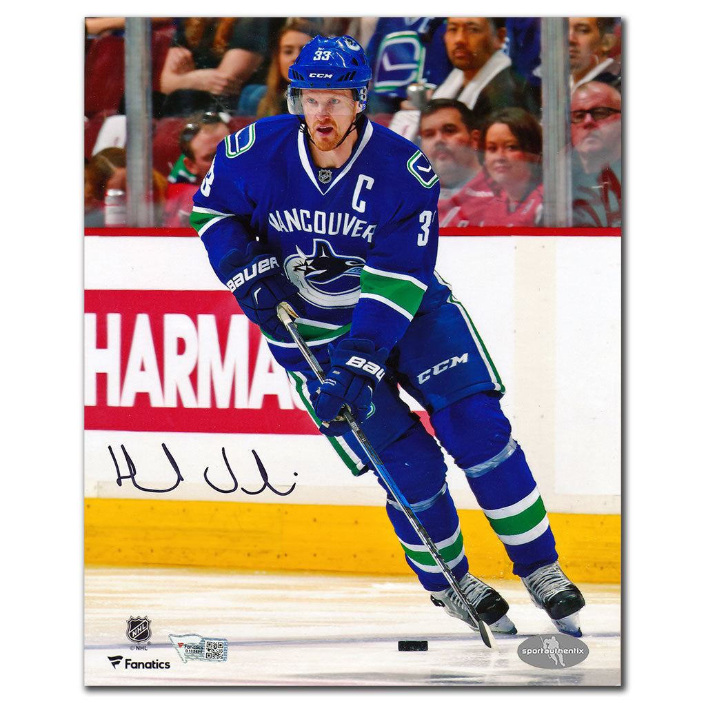 Henrik Sedin autographed Vancouver Canucks 8x10 photo in blue jersey skating with puck