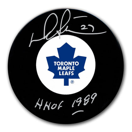 Darryl Sittler autographed Toronto Maple Leafs puck featuring white and blue logo, inscribed HOF 1989.