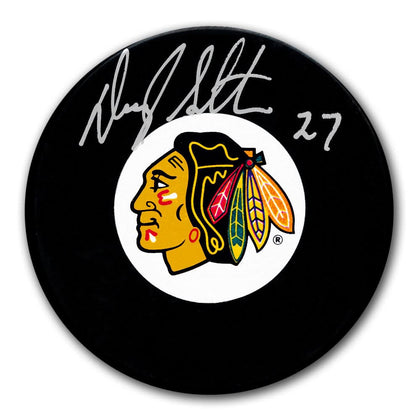 Darryl Sutter signed Chicago Blackhawks hockey puck featuring #27 and Native American head logo, includes certificate of authenticity.