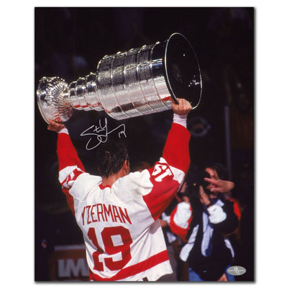 Steve Yzerman hoists the Cup in a Red Wings jersey on this signed 16x20 photo, autographed and dated from 1997.